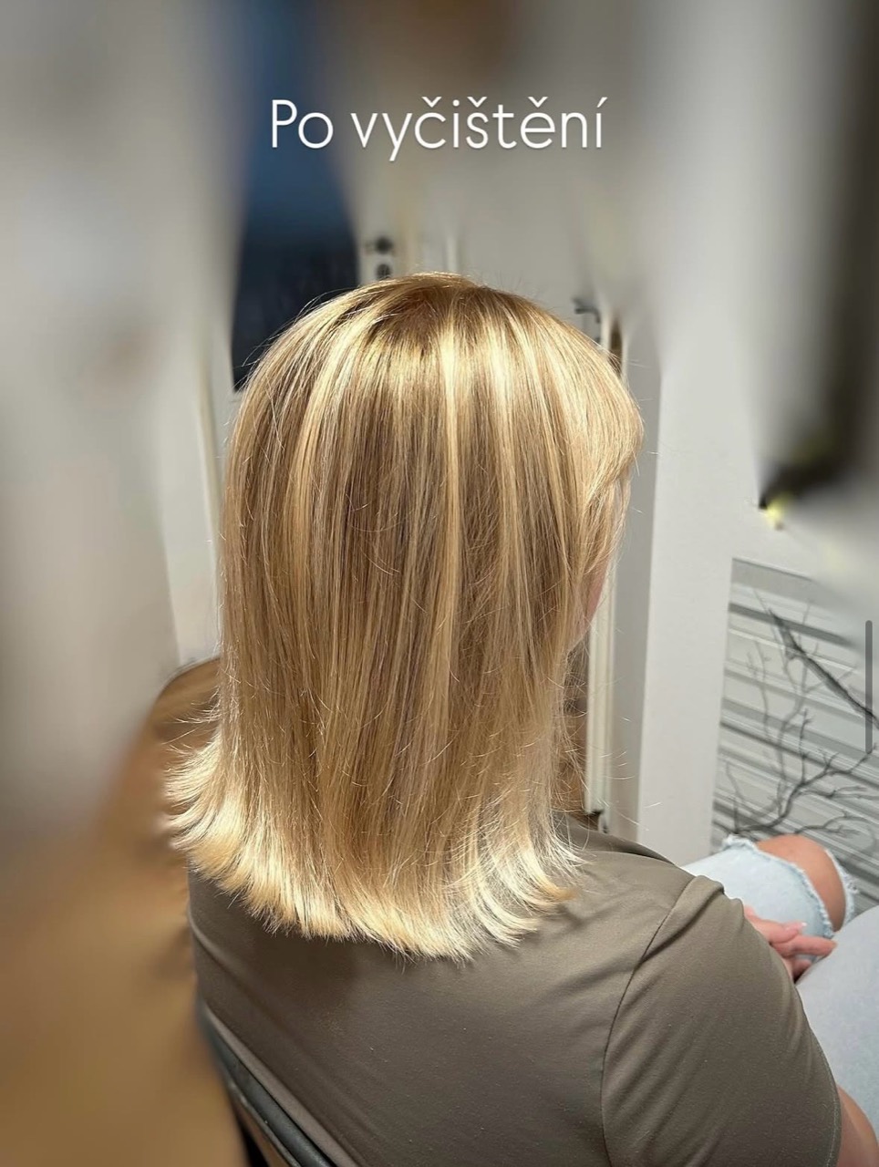 Blond vlasy po vyčištění nechtěného odstínu; viditelný teplejší tón před dalším tónováním